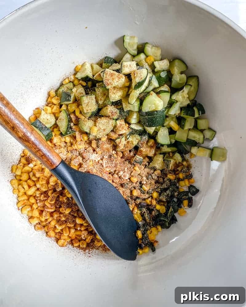 Roasted Harvest Tacos 12 various roasted vegetables mixed with spices in a white bowl against a white background.