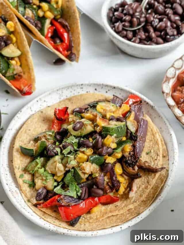 Roasted Harvest Tacos 15 A close-up shot of a perfectly assembled Vegan Roasted Veggie Taco, showcasing the vibrant filling and fresh garnishes, ready to be enjoyed.