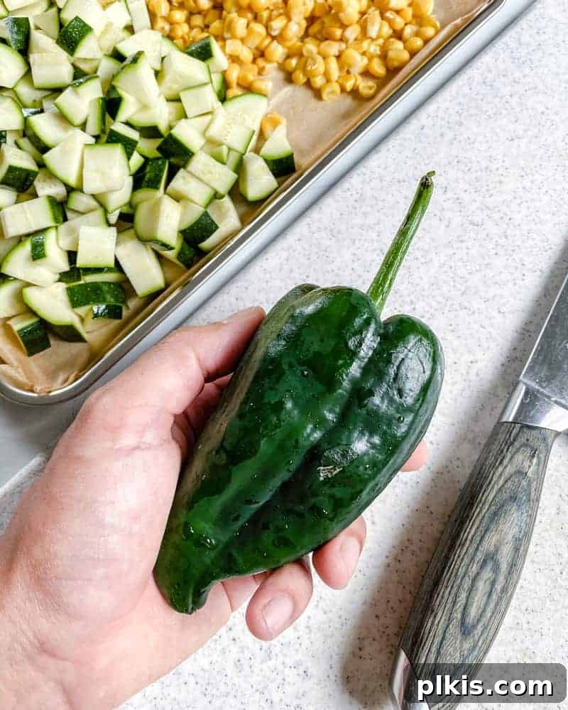 Roasted Harvest Tacos 6 diced green pepper with knife against a white background, with other chopped ingredients in the background.