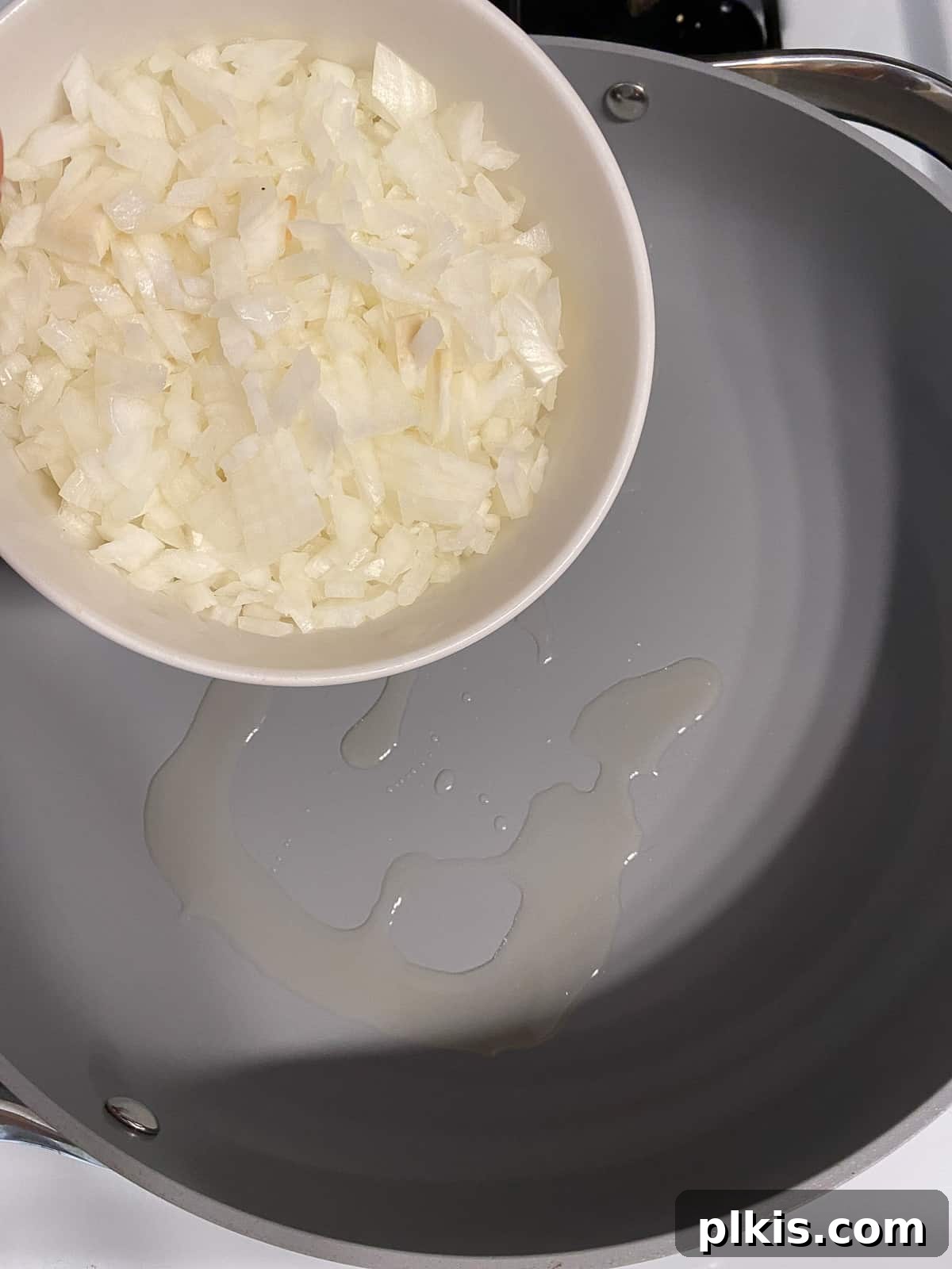 Gourmet Vegan French Onion Dip 4 Process shot showing finely chopped onions being added to a hot skillet with oil, ready to be caramelized for Vegan French Onion Dip.