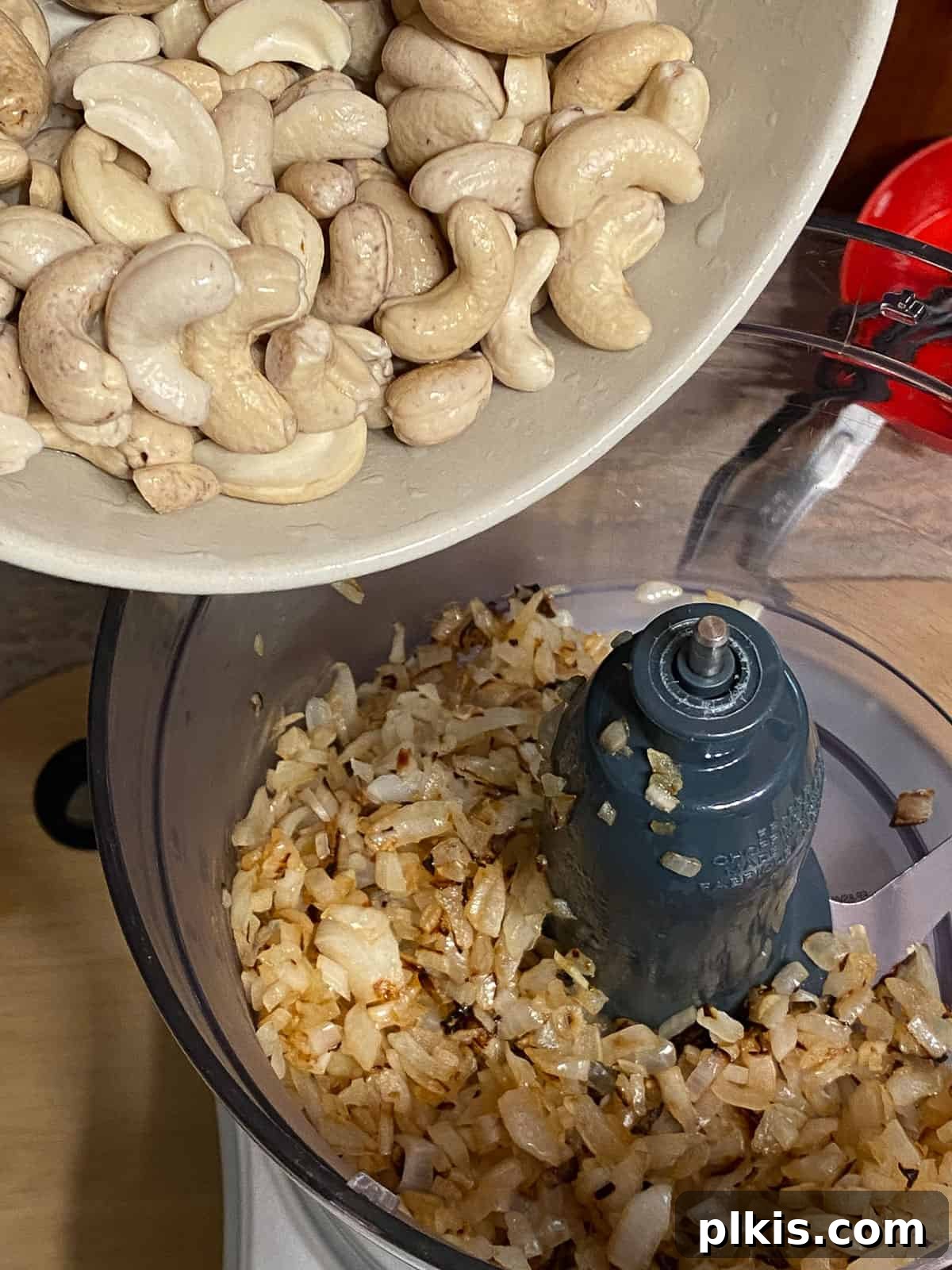 Gourmet Vegan French Onion Dip 5 Process shot: Soaked cashews are being added to a food processor, ready to be blended into a creamy base for the dip.