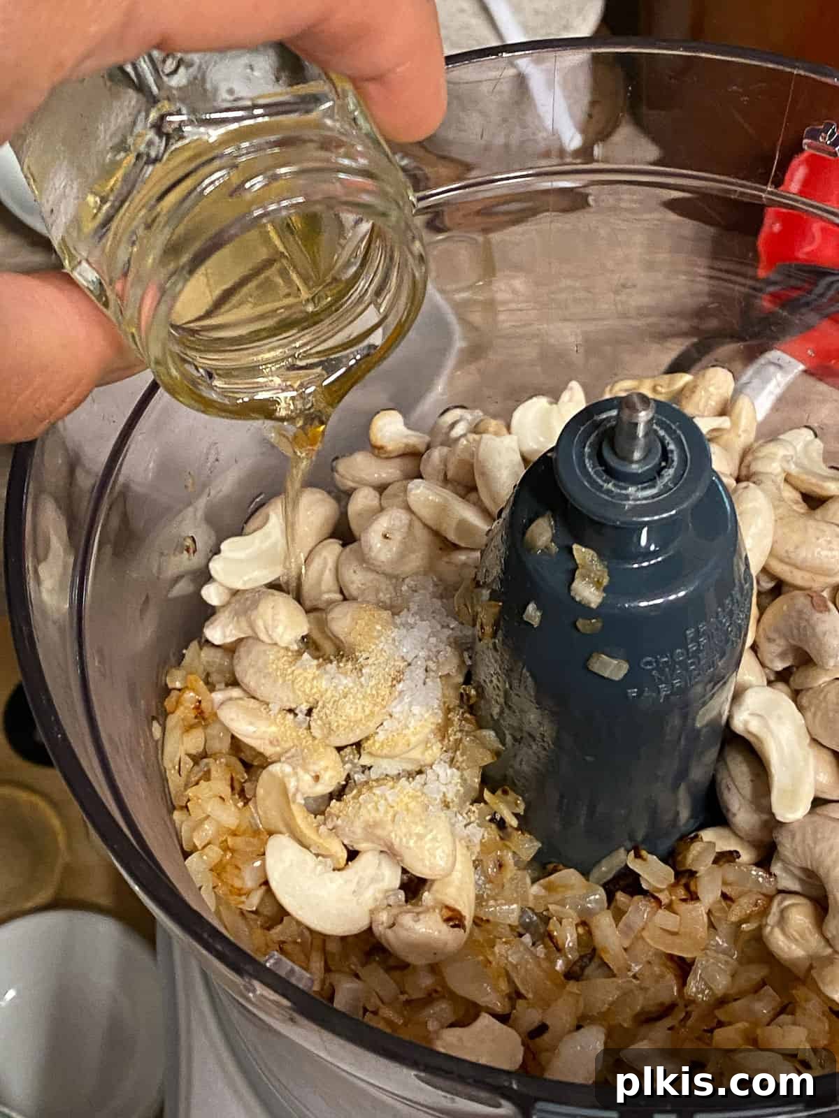 Gourmet Vegan French Onion Dip 8 Process shot: A small amount of oil is being poured into the food processor with the other dip ingredients.