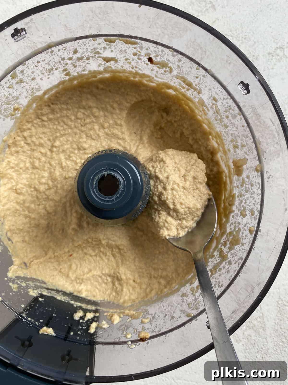 Gourmet Vegan French Onion Dip 10 Process shot: A spoonful of the creamy, blended dip in a food processor, showing its perfect smooth texture.