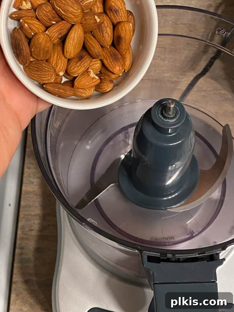 Plant-Powered Bean Dip 9 process shot of adding almonds to food processor