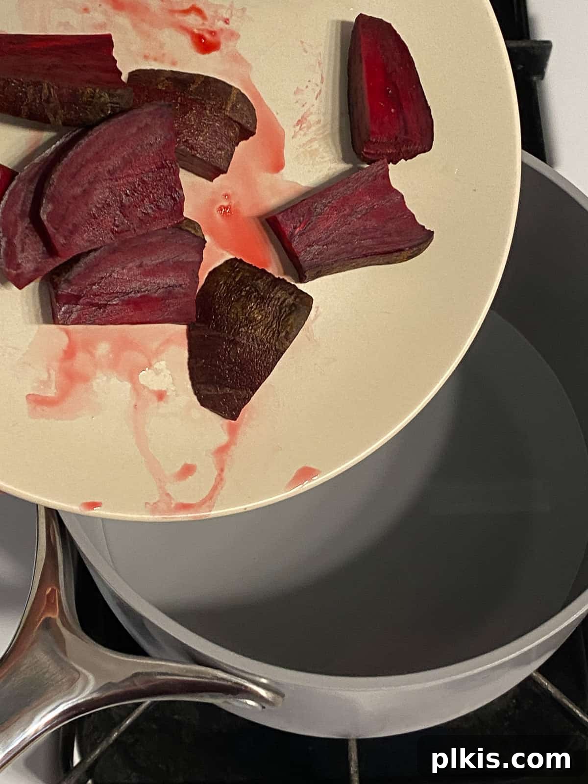 Ruby Red Beet & Banana Bliss 4 A close-up process shot showing chopped beets being added to a pot of boiling water on a stovetop, demonstrating the first step in preparing the smoothie.