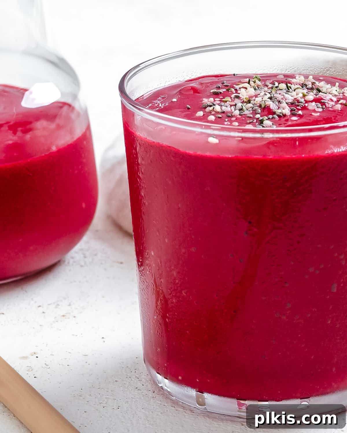 Ruby Red Beet & Banana Bliss 7 Two glasses of completed Banana Beet Smoothies, beautifully presented on a light background, showcasing their vivid color and inviting appeal.