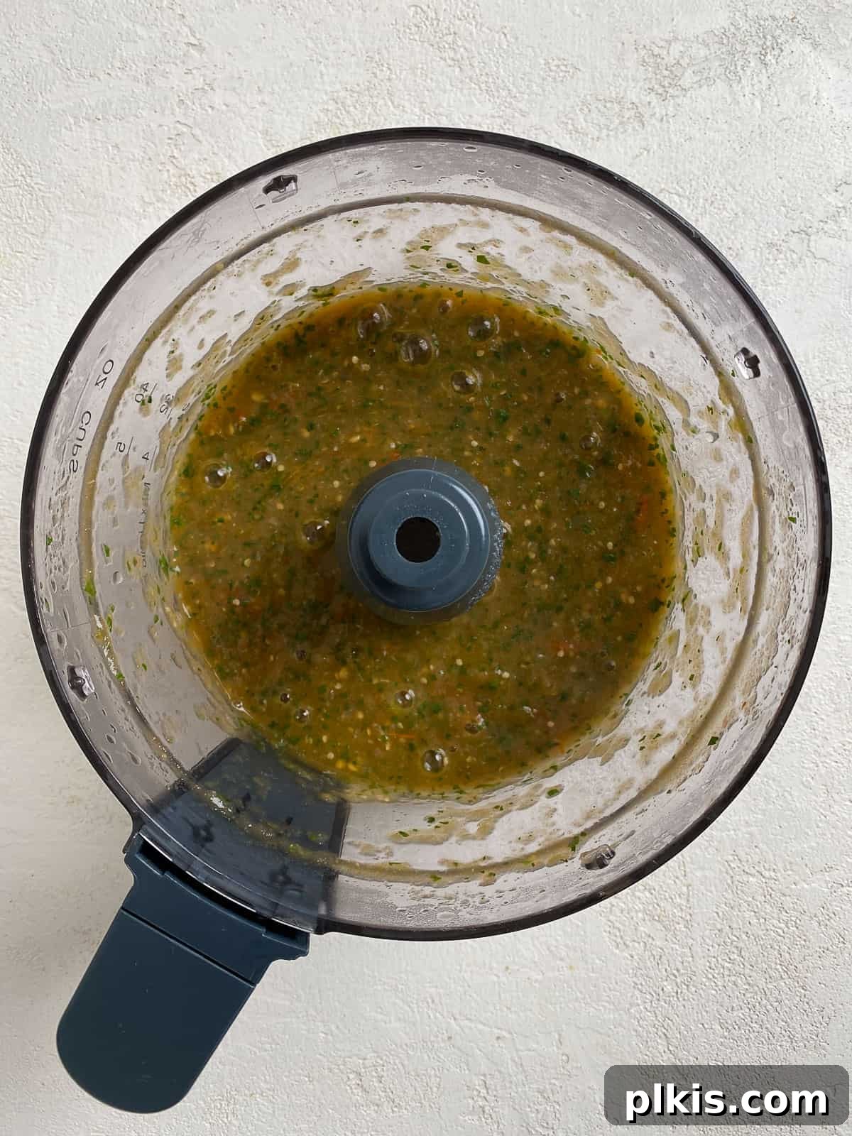 Zesty Tomatillo Green Chili Salsa 11 Freshly blended stovetop tomatillo salsa in a food processor, showcasing its smooth texture.