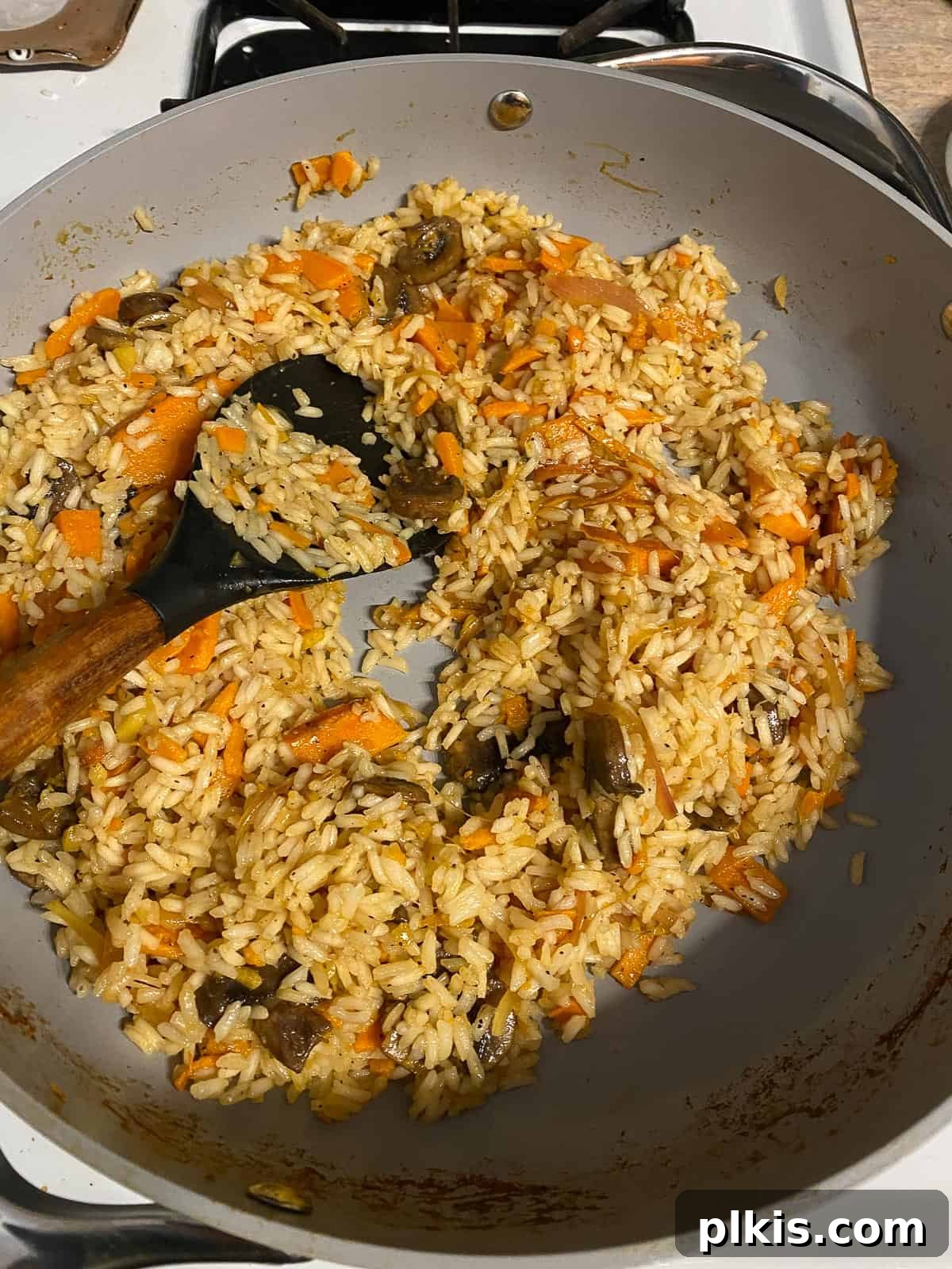 Nourishing Sweet Potato Fried Rice 14 Rice and vegetables being mixed together in the pan.