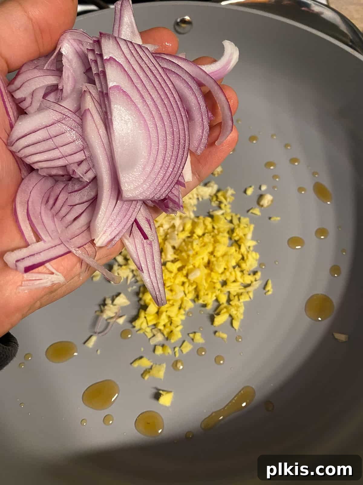 Nourishing Sweet Potato Fried Rice 7 Red onion slices being added to the sautéing aromatics.