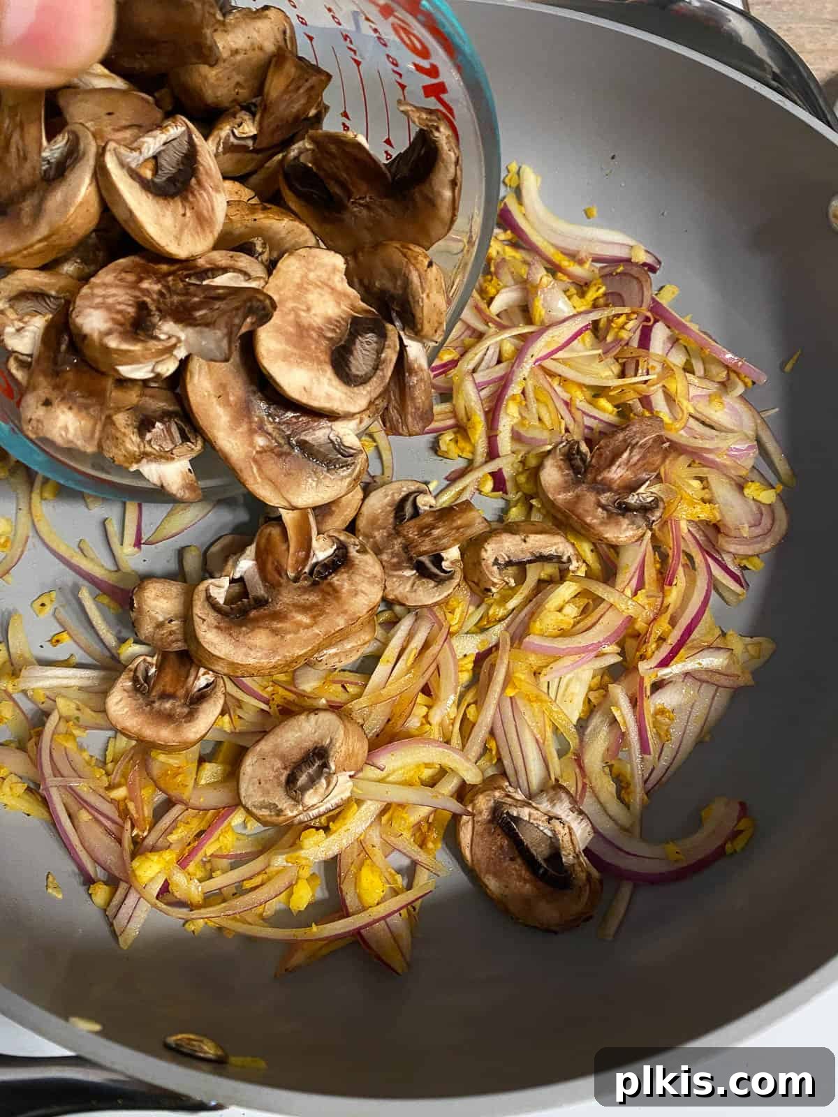 Nourishing Sweet Potato Fried Rice 9 Sliced mushrooms being added to the pan with sautéed aromatics.