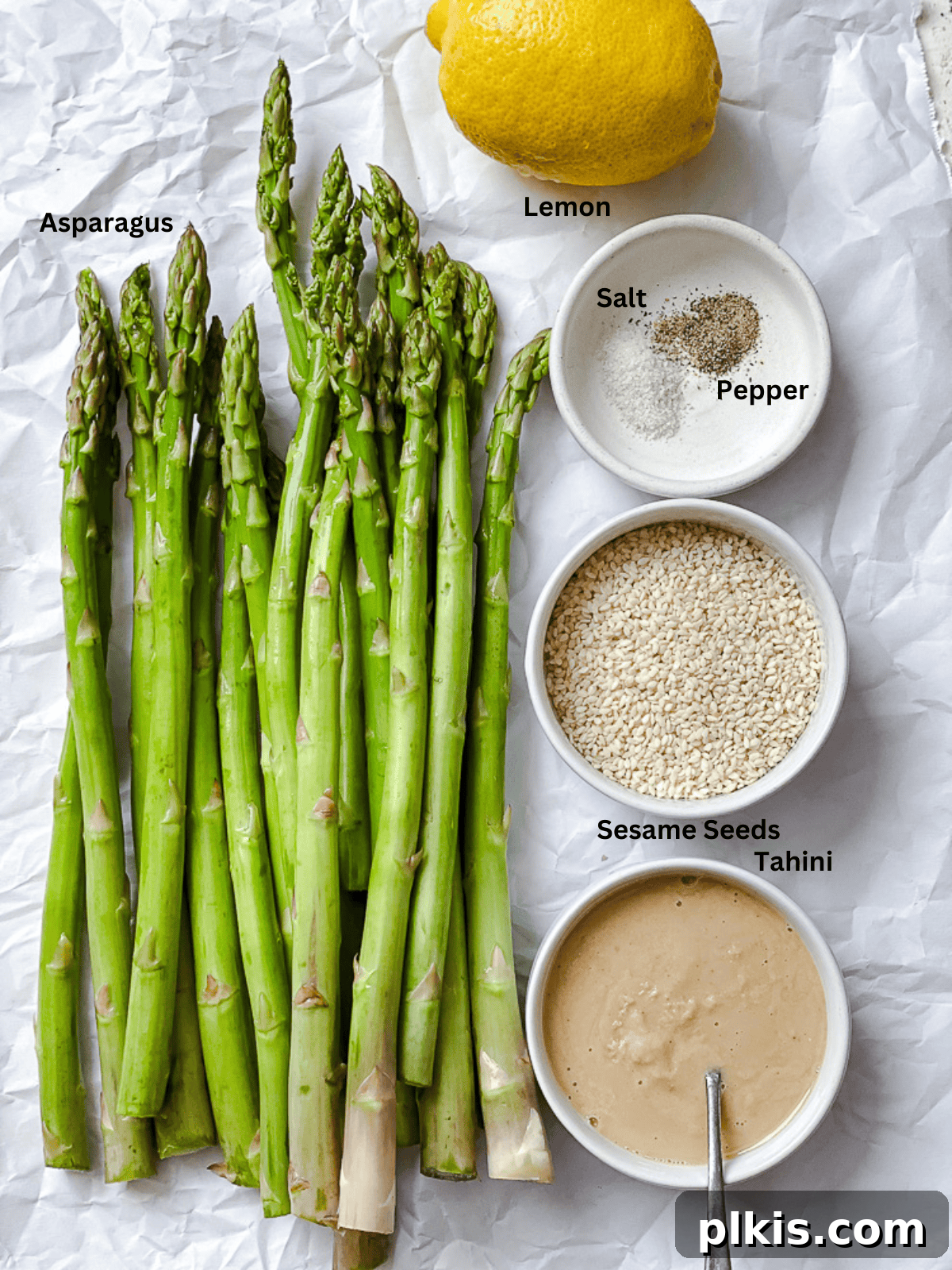 Ingredients for Roasted Asparagus measured out on a white surface.