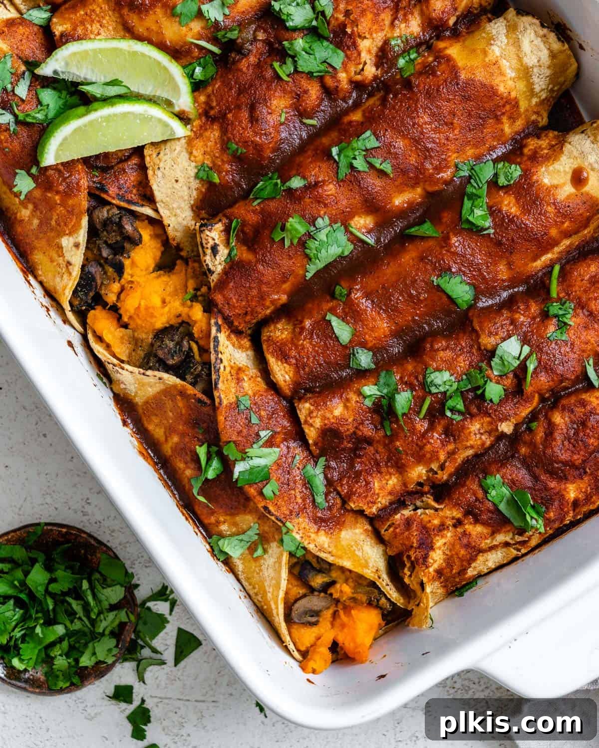 Golden Sweet Potato Rolls 2 A vibrant baking dish filled with freshly baked vegan sweet potato enchiladas, topped with lush green cilantro, ready to be served.