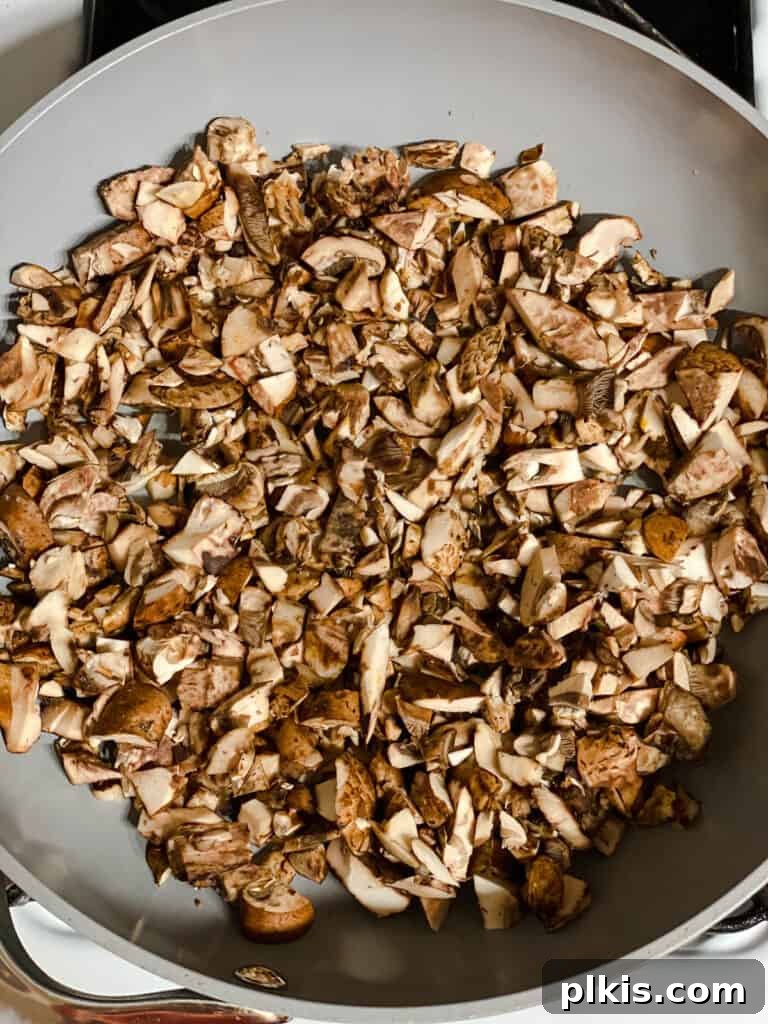 Golden Sweet Potato Rolls 6 Process shot of sliced mushrooms sizzling in a pan over medium heat, releasing their moisture.