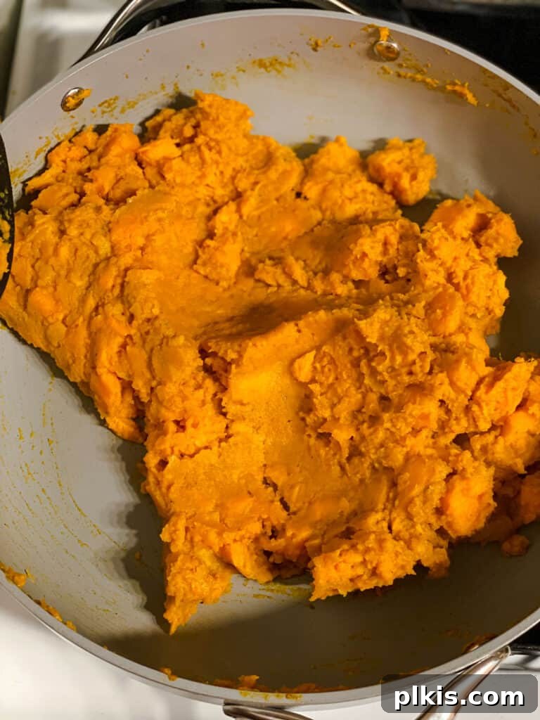 Golden Sweet Potato Rolls 10 Close-up shot of the perfectly mashed sweet potato mixture in a pan, seasoned and ready for the enchilada filling.