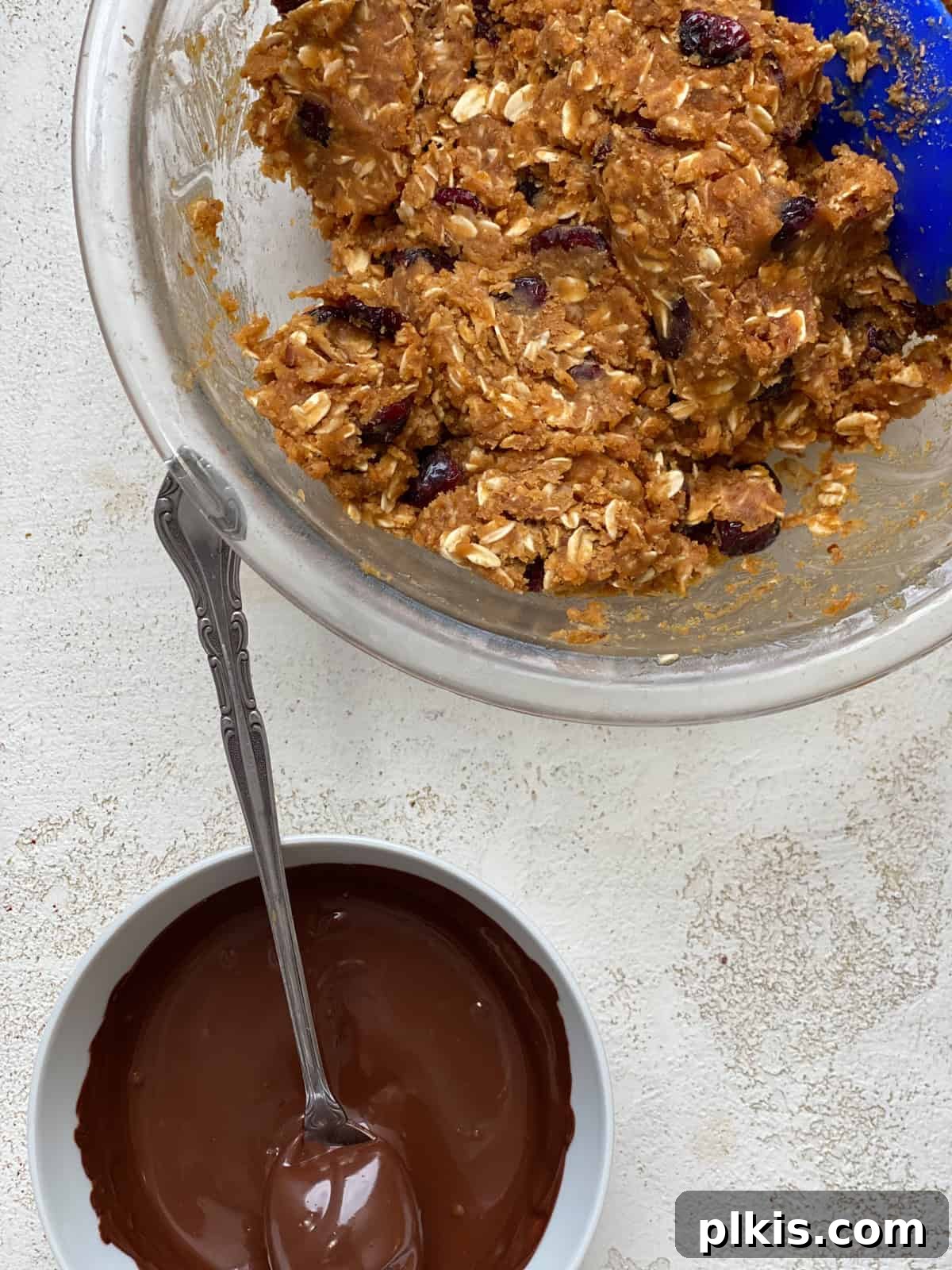 Chilled Peanut Butter Perfection 5 A process shot showing melted vegan chocolate being drizzled into the mixed oatmeal and peanut butter base in a bowl, ready to be incorporated.