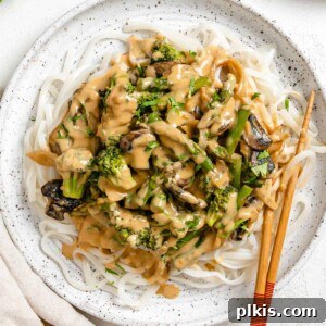 completed Vegan Rice Noodle Recipe with Tahini Stir Fry Sauce plated on a white plate with chopsticks