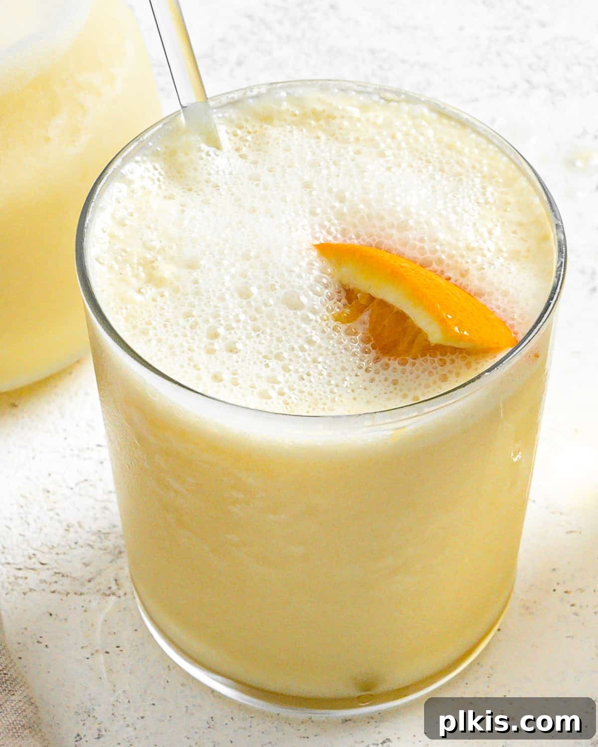Creamy Orange Dream Smoothie 6 Completed Easy Orange Julius Smoothies in elegant glass cups with a pitcher in the background, showcasing the creamy texture and vibrant orange color, ready to drink.