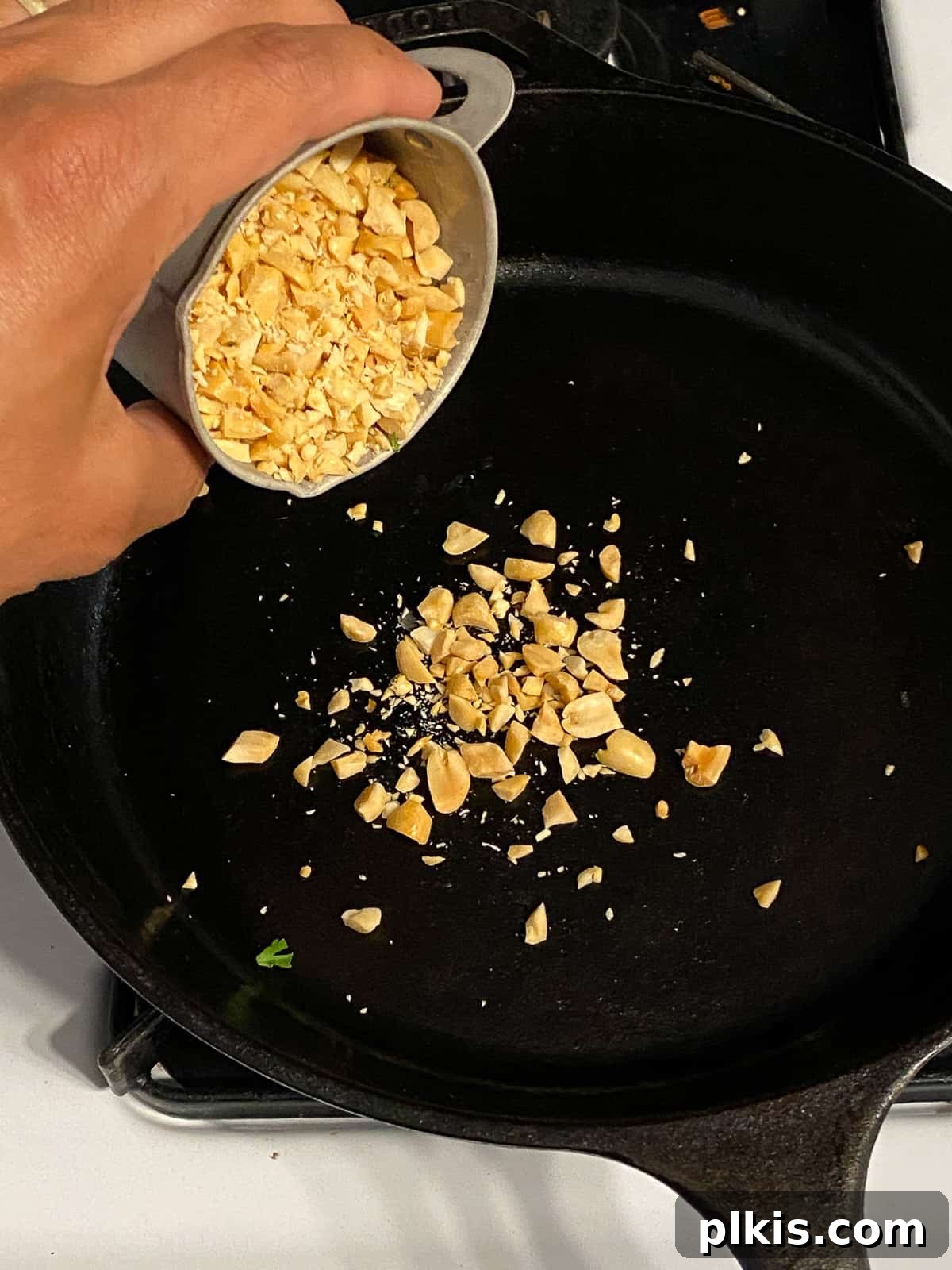 Process of adding chopped peanuts to the pan.