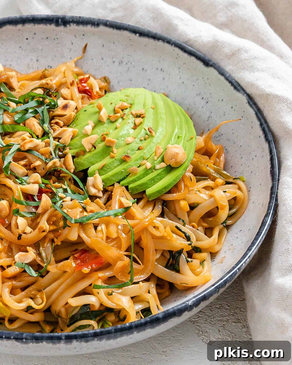 Completed Vegan Vegetable Pad Thai plated against a light background, ready to be served.