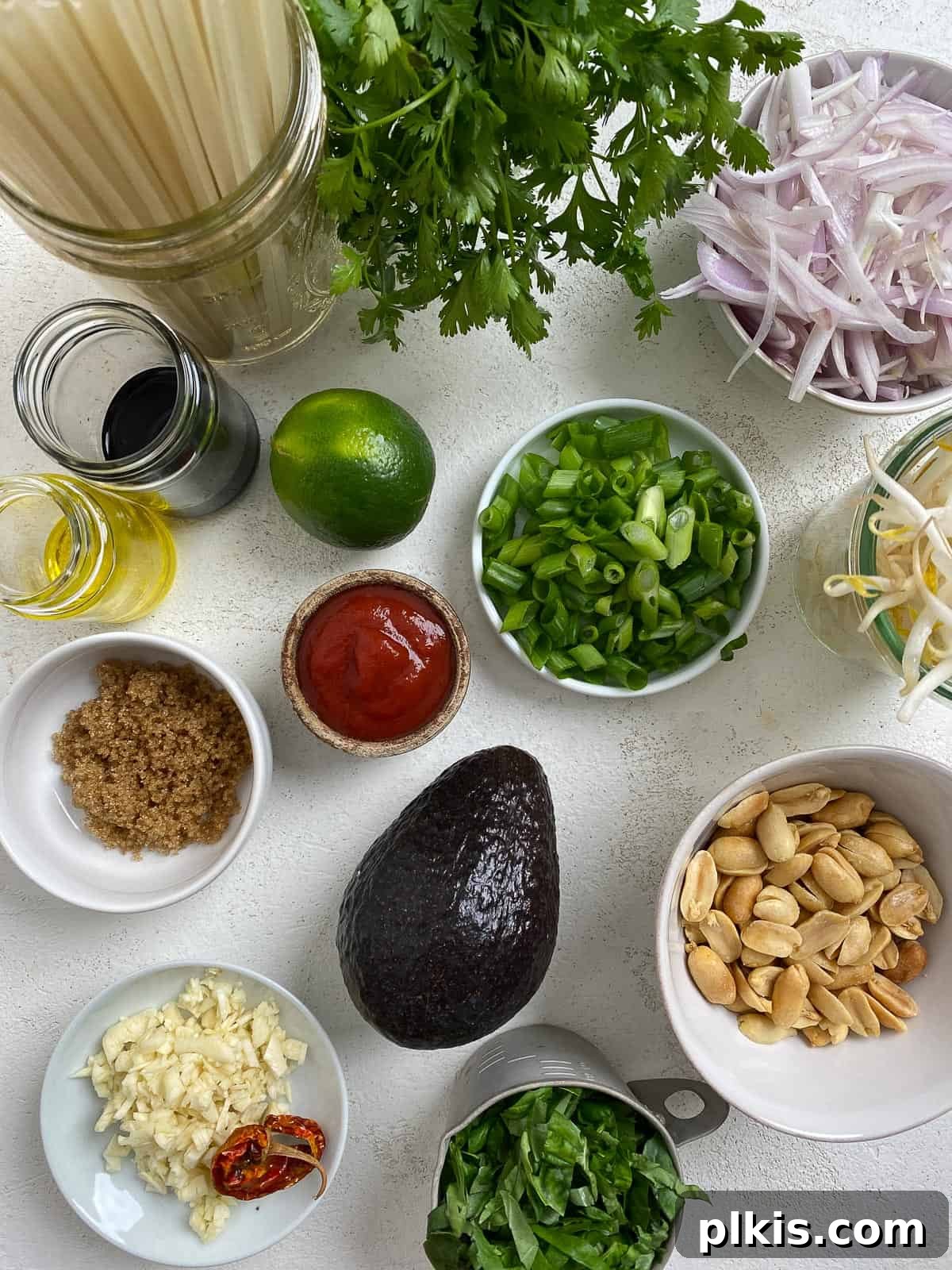 Ingredients for Vegan Vegetable Pad Thai measured out and arranged on a white surface.