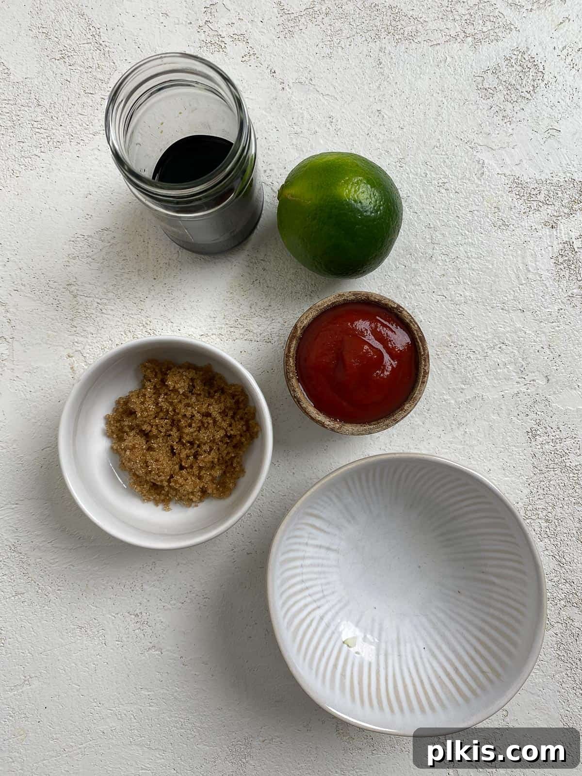 Ingredients for Pad Thai sauce measured out in bowls against a white surface.
