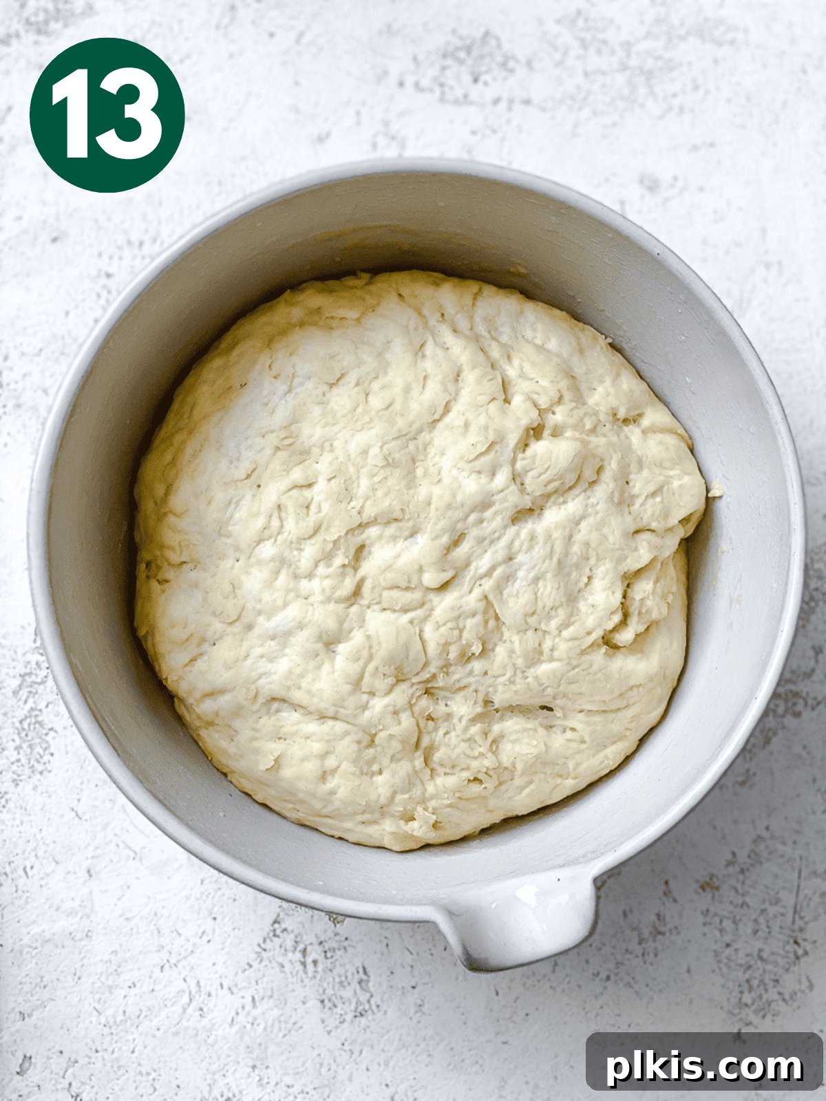 Heavenly Vegan Cinnamon Rolls 16 Visibly risen dough in a large white bowl, indicating a successful first proof.