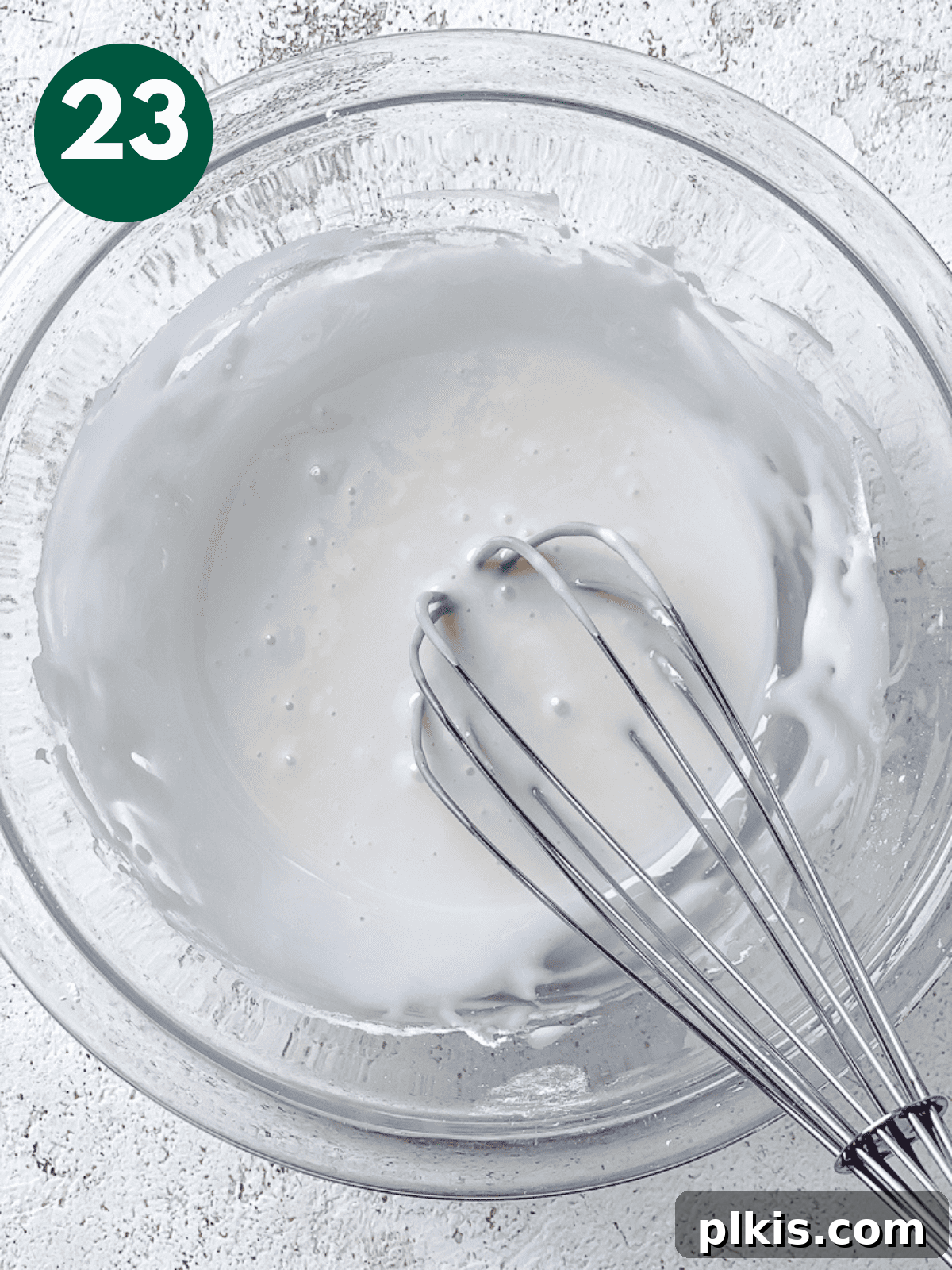 Heavenly Vegan Cinnamon Rolls 26 Whisking vanilla icing ingredients together in a large glass bowl until smooth.