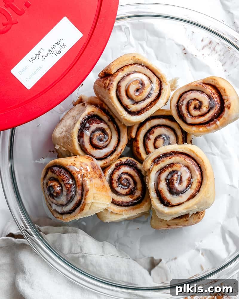 Heavenly Vegan Cinnamon Rolls 30 Vegan cinnamon rolls stored in a large glass bowl with a lid on the side labeled "vegan cinnamon rolls".