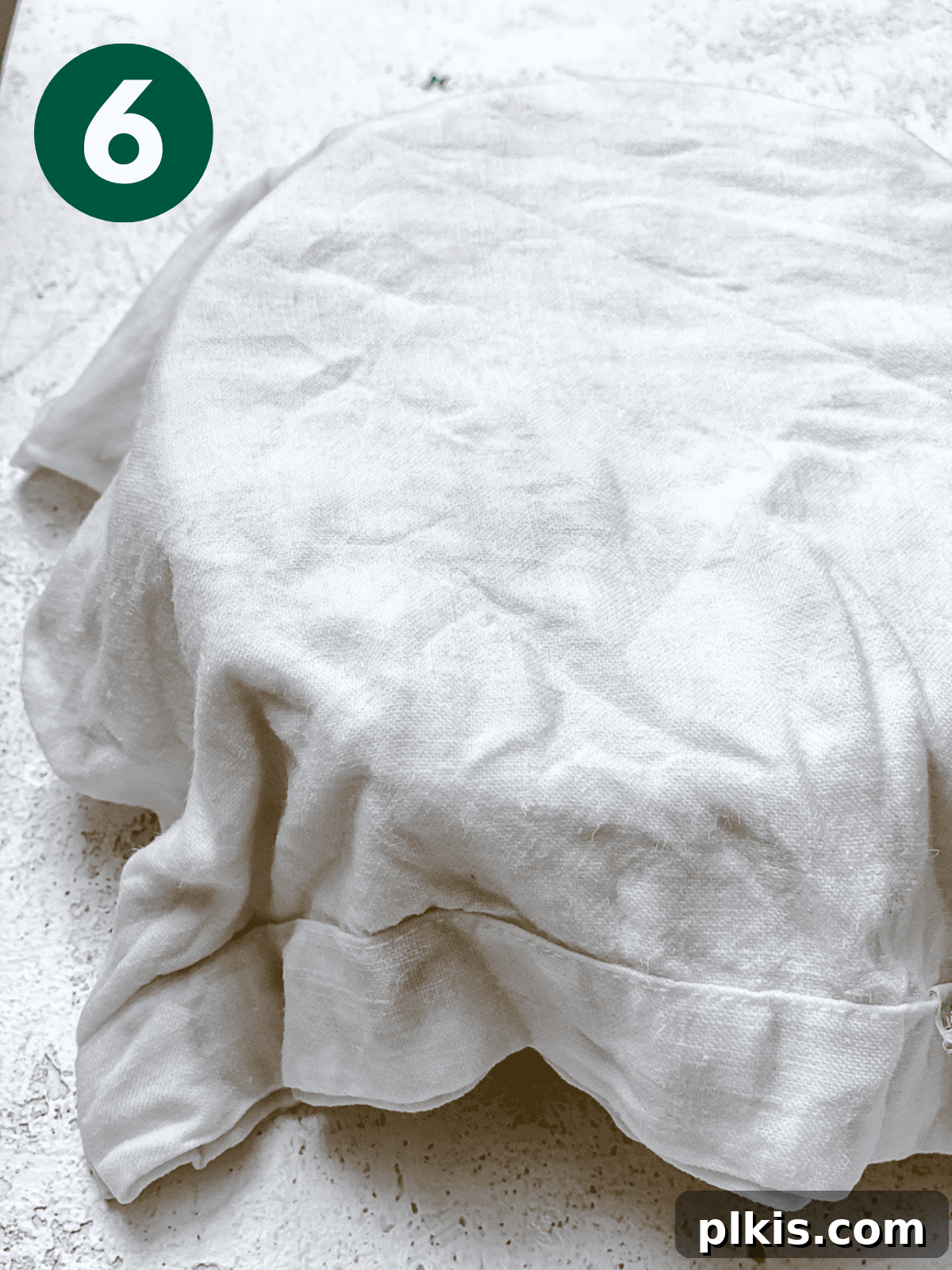 Heavenly Vegan Cinnamon Rolls 9 A white kitchen towel covering a bowl of yeast mixture, allowing it to rest and proof.