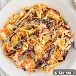 completed coleslaw in a white bowl against a white surface