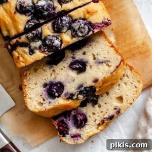 Completed Easy Blueberry Bread [Quick Bread!] on a cutting board, ready for serving.