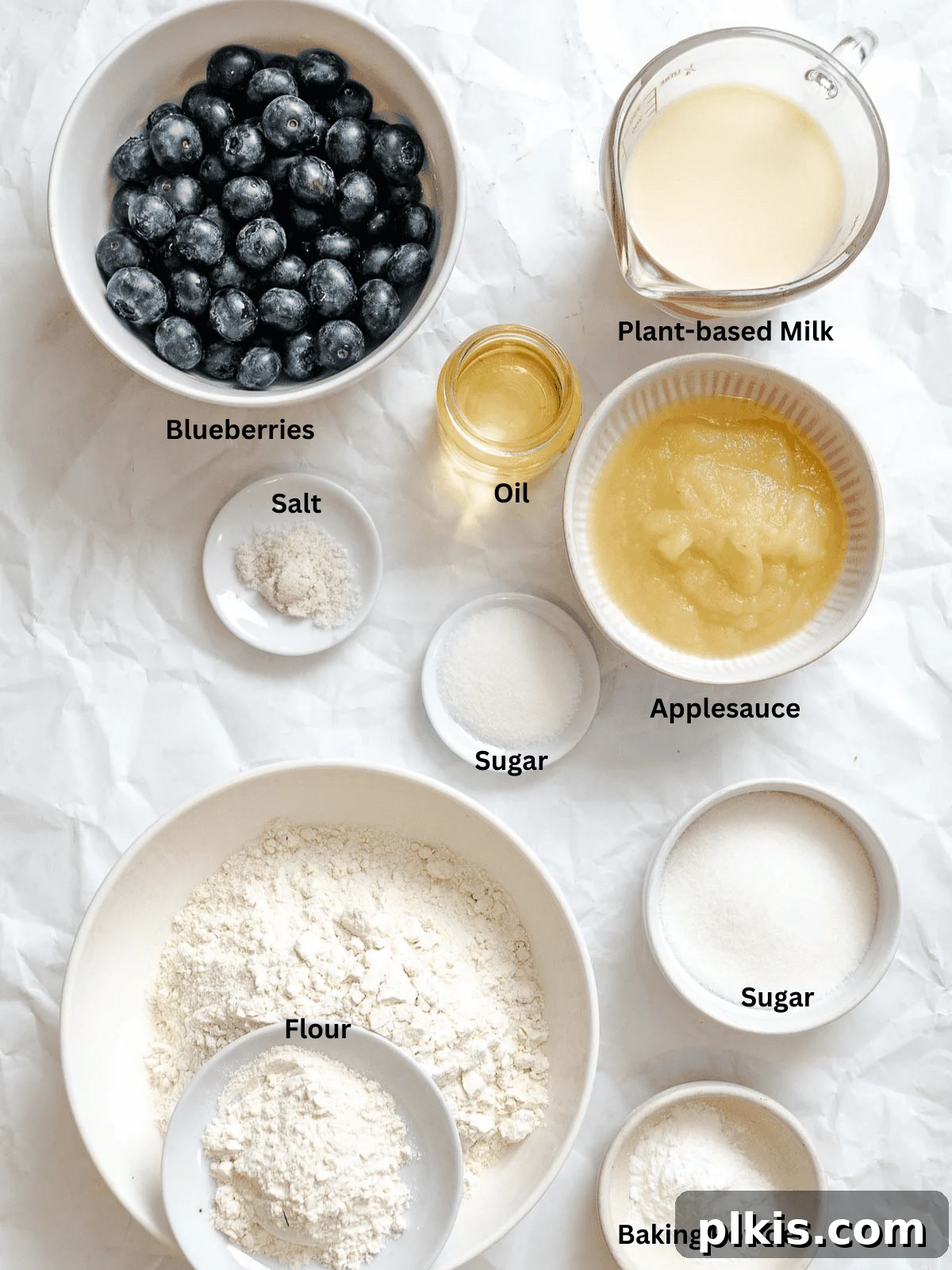 Ingredients for Easy Blueberry Bread [Quick Bread!] measured out on a white surface, showcasing fresh blueberries, flour, sugar, and wet ingredients.