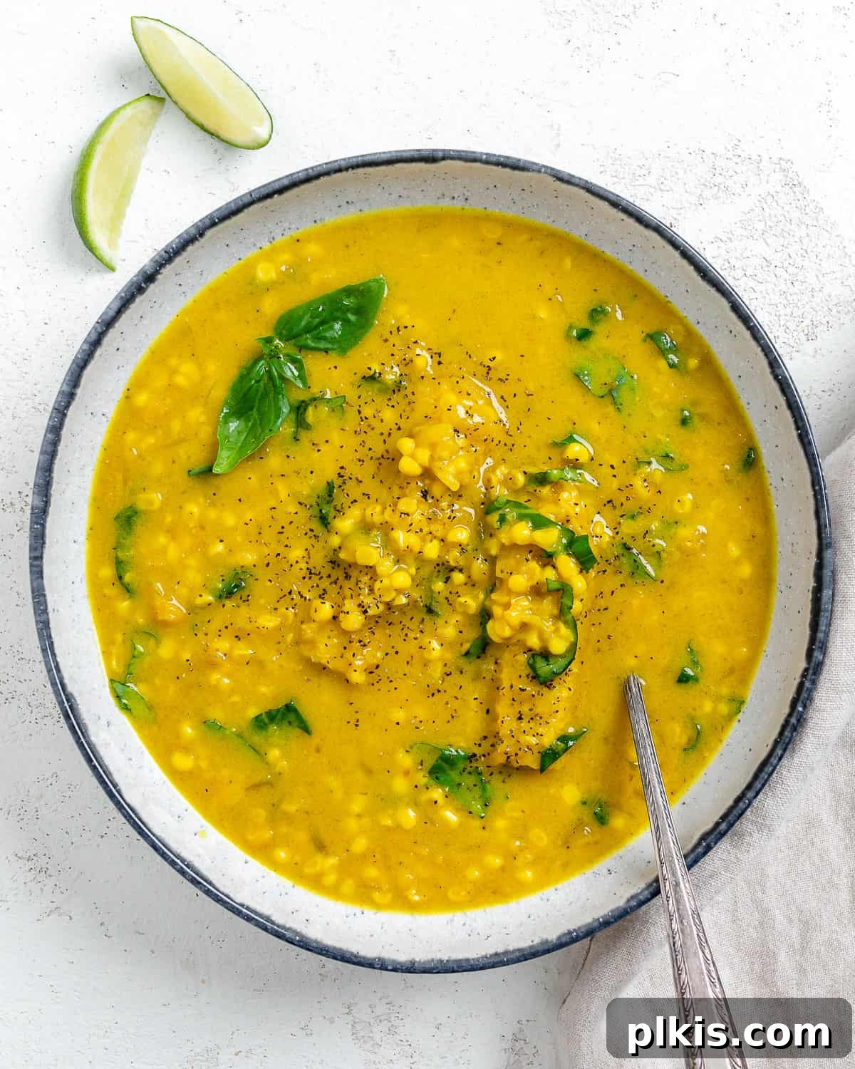 Velvety Vegan Coconut Corn Chowder 2 A comforting bowl of creamy vegan corn chowder with coconut milk, garnished with fresh herbs, set against a light background.