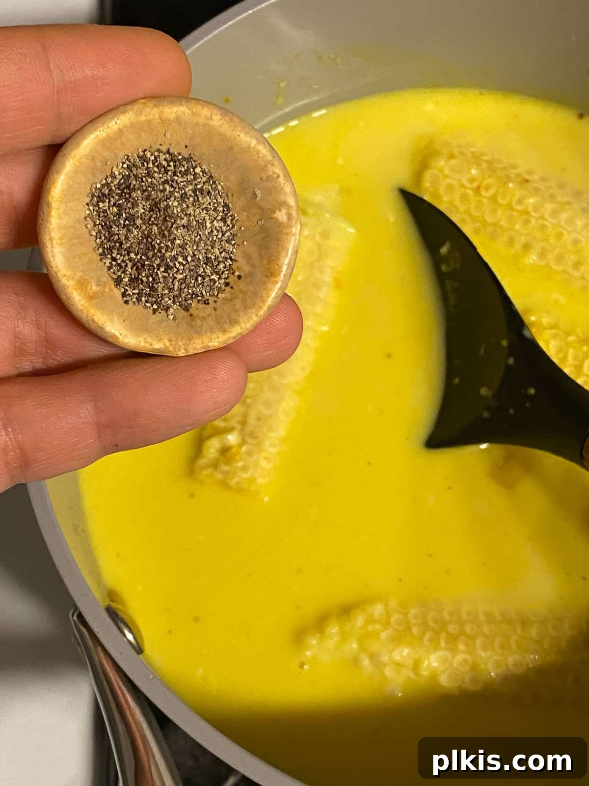 Velvety Vegan Coconut Corn Chowder 15 Step 2: Finishing the seasoning with black pepper for a balanced flavor.