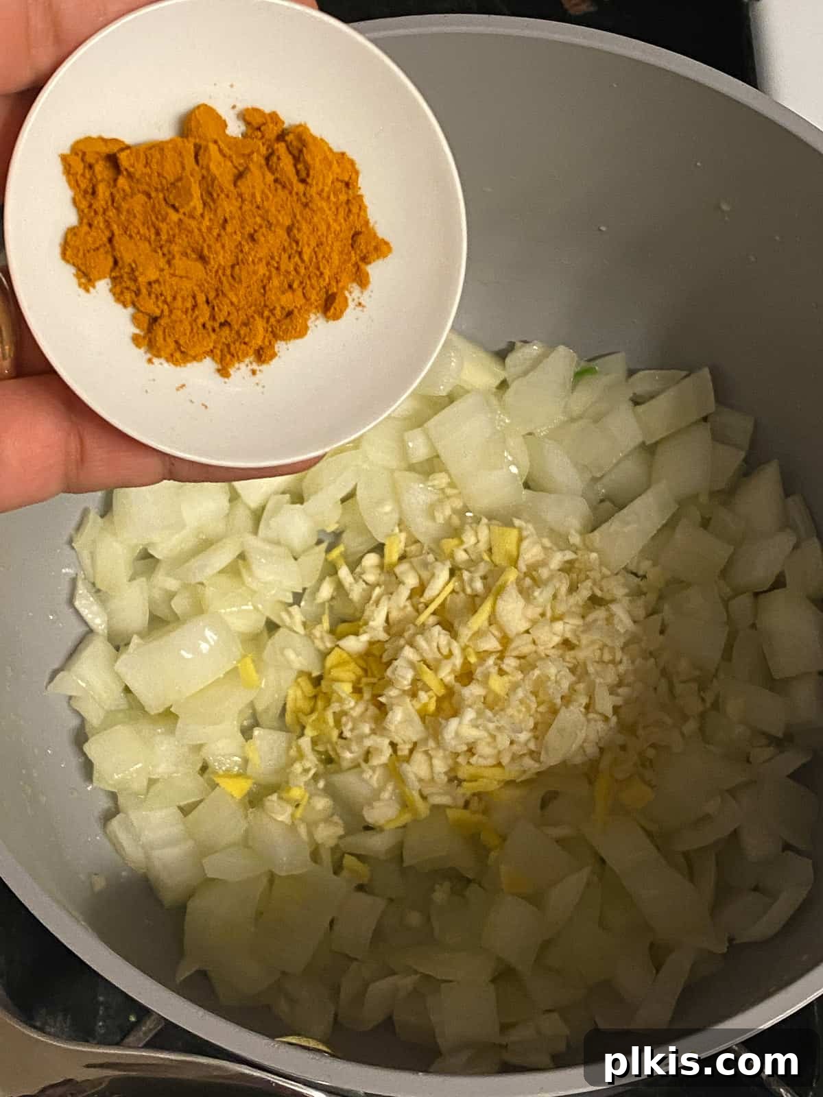 Velvety Vegan Coconut Corn Chowder 7 Step 1: Sprinkling ground turmeric into the pot with the sautéing aromatics.