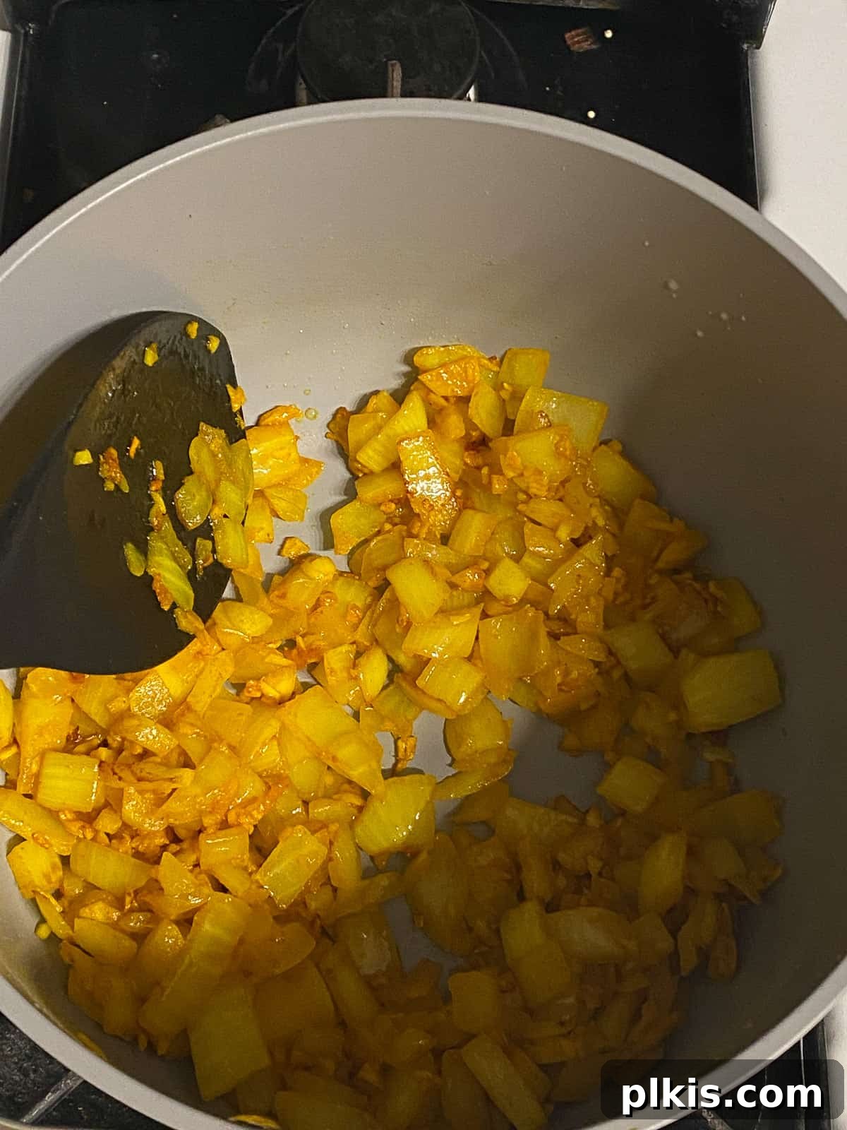 Velvety Vegan Coconut Corn Chowder 8 Step 1: Stirring the garlic, ginger, onion, and turmeric as they sauté in the pot.