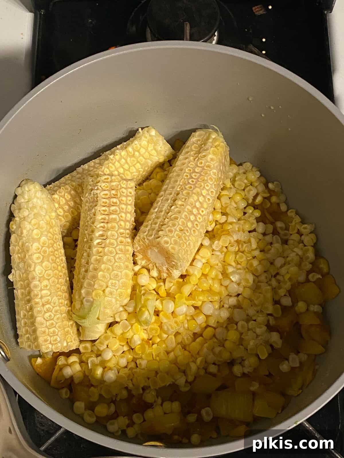 Velvety Vegan Coconut Corn Chowder 10 Step 2: Placing corn cobs into the pot to enhance flavor.