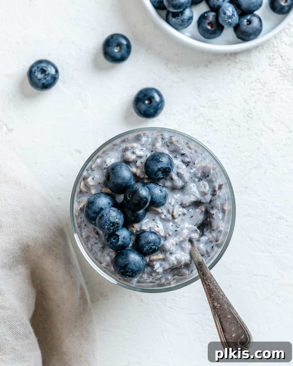 Overnight Blueberry Delight 17 A vibrant bowl of Blueberry Overnight Oats, freshly prepared and garnished with extra blueberries, presented on a light background. Emphasizes health and convenience for meal prep.