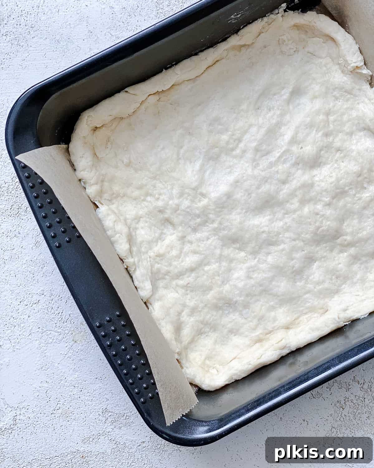 Vibrant Zucchini Tart 8 The tart crust dough expertly pressed into a baking pan, forming an even base for the filling.