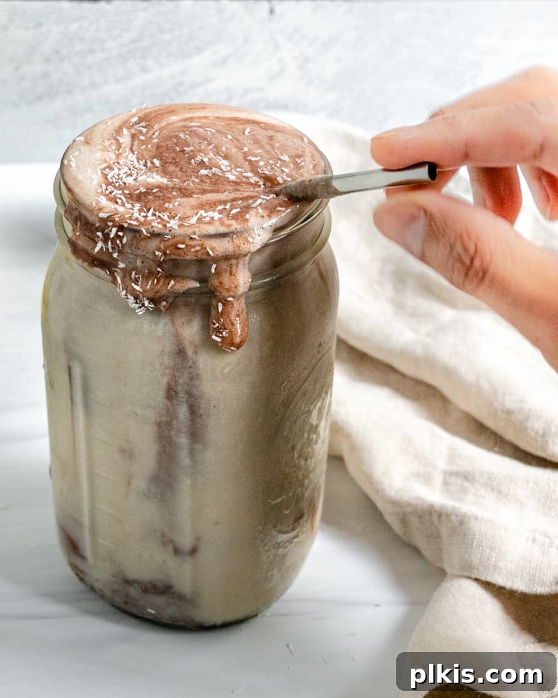 Chocolate Peanut Butter Banana Dream 7 Completed Chocolate Peanut Butter Banana Smoothie in a jar with ingredients in the background, garnished with shredded coconut