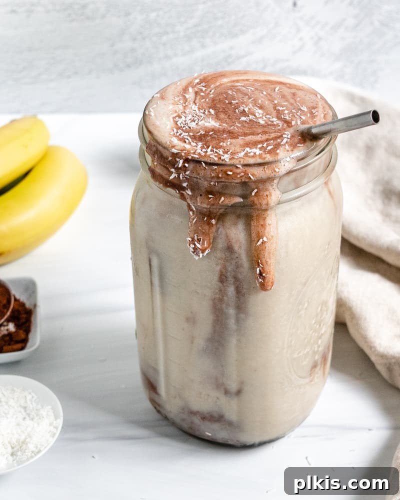 Chocolate Peanut Butter Banana Dream 8 Completed Chocolate Peanut Butter Banana Smoothie in a jar with ingredients in the background, showing off the creamy texture
