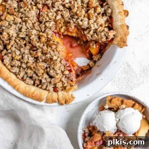 completed Peach Crumb Pie with a slice in a separate white bowl
