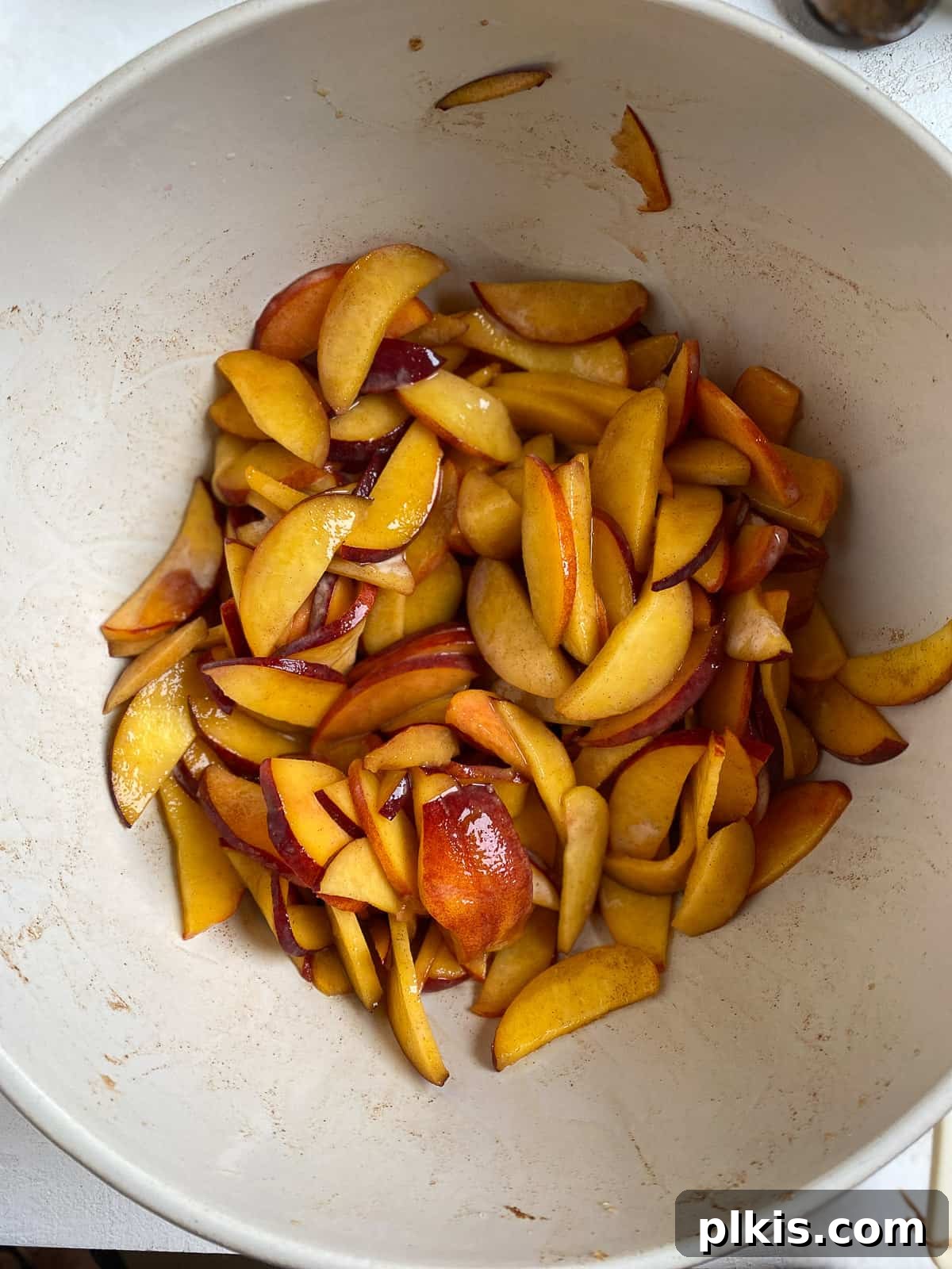 sliced peaches in a white bowl