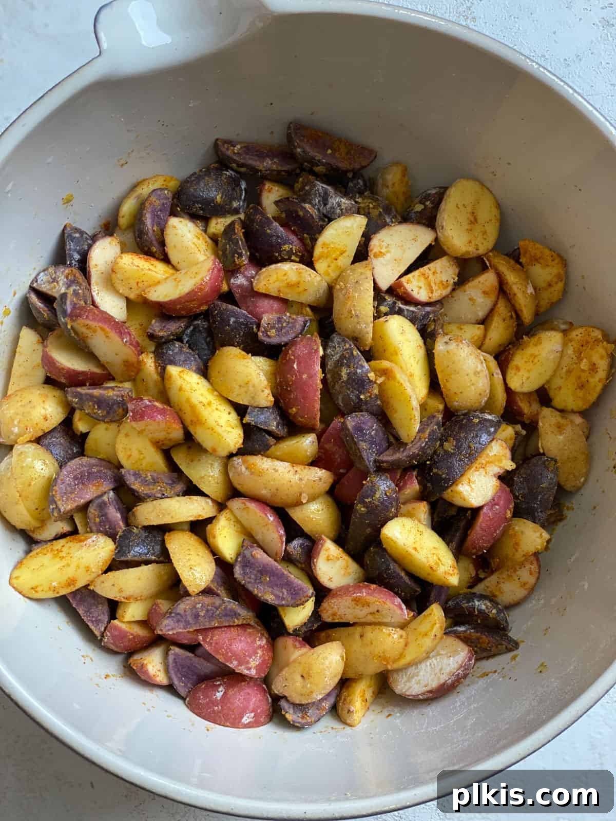 Crispy Purple Potato Perfection 4 process shot of mixed ingredients for Crispy Purple Potatoes Recipe together in a bowl