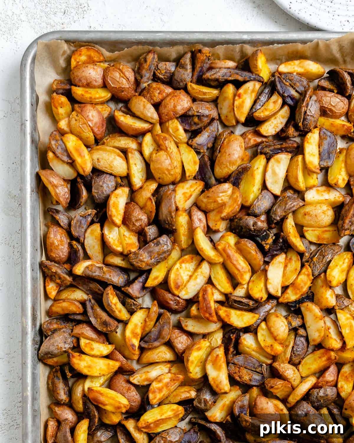 Crispy Purple Potato Perfection 6 completed Crispy Purple Potatoes on a baking tray against a white background