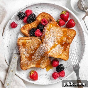 completed Vegan French Toast plated with fruits on a white plate