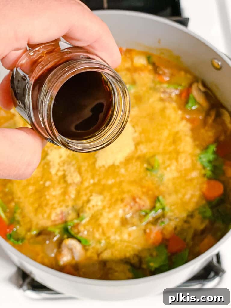Comforting Red Lentil Stew 14 Balsamic vinegar being drizzled into the Hearty Red Lentil Stew to brighten the flavors.