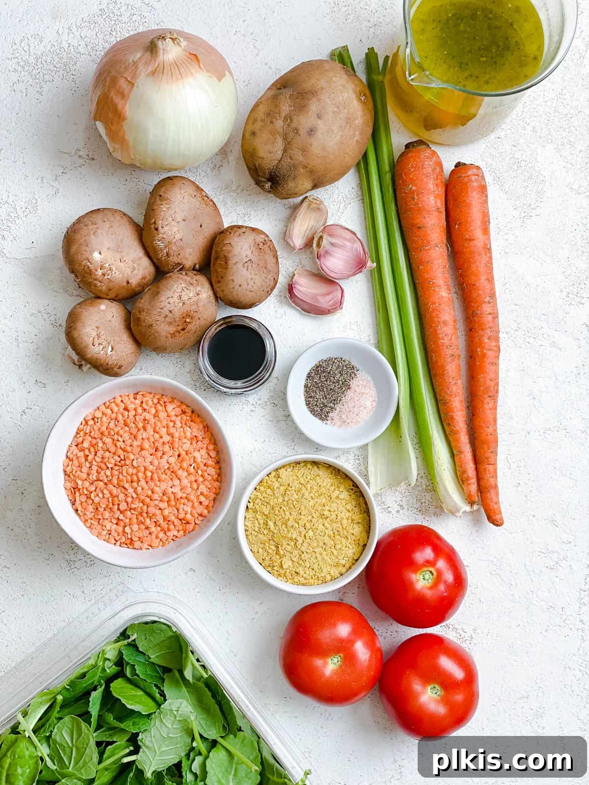 Comforting Red Lentil Stew 3 A curated selection of fresh ingredients for Hearty Red Lentil Stew, including vibrant vegetables and red lentils, neatly arranged on a white surface.