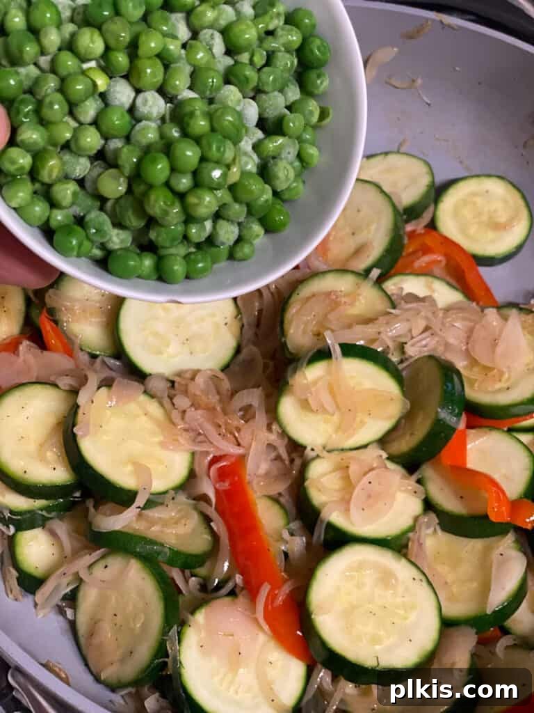Vibrant Vegetable Sauté with Golden Baby Potatoes 8 Adding bell peppers and zucchini to the pan with sautéed shallots.