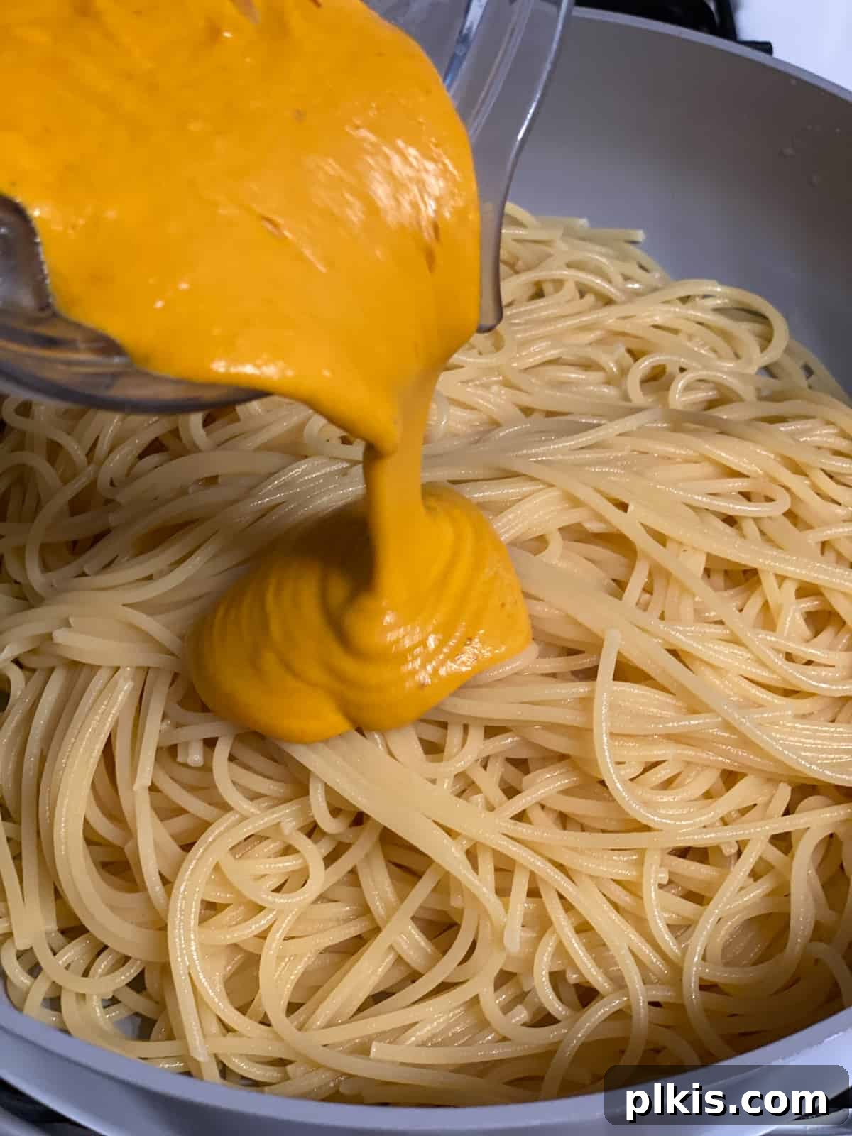 Velvety Sweet Potato Spaghetti 13 Process of adding sweet potato pasta sauce to cooked spaghetti in a large bowl